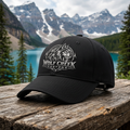 Concept mockup of the Wolf Creek Customs black logo hat with mountain, forest and lake scenery